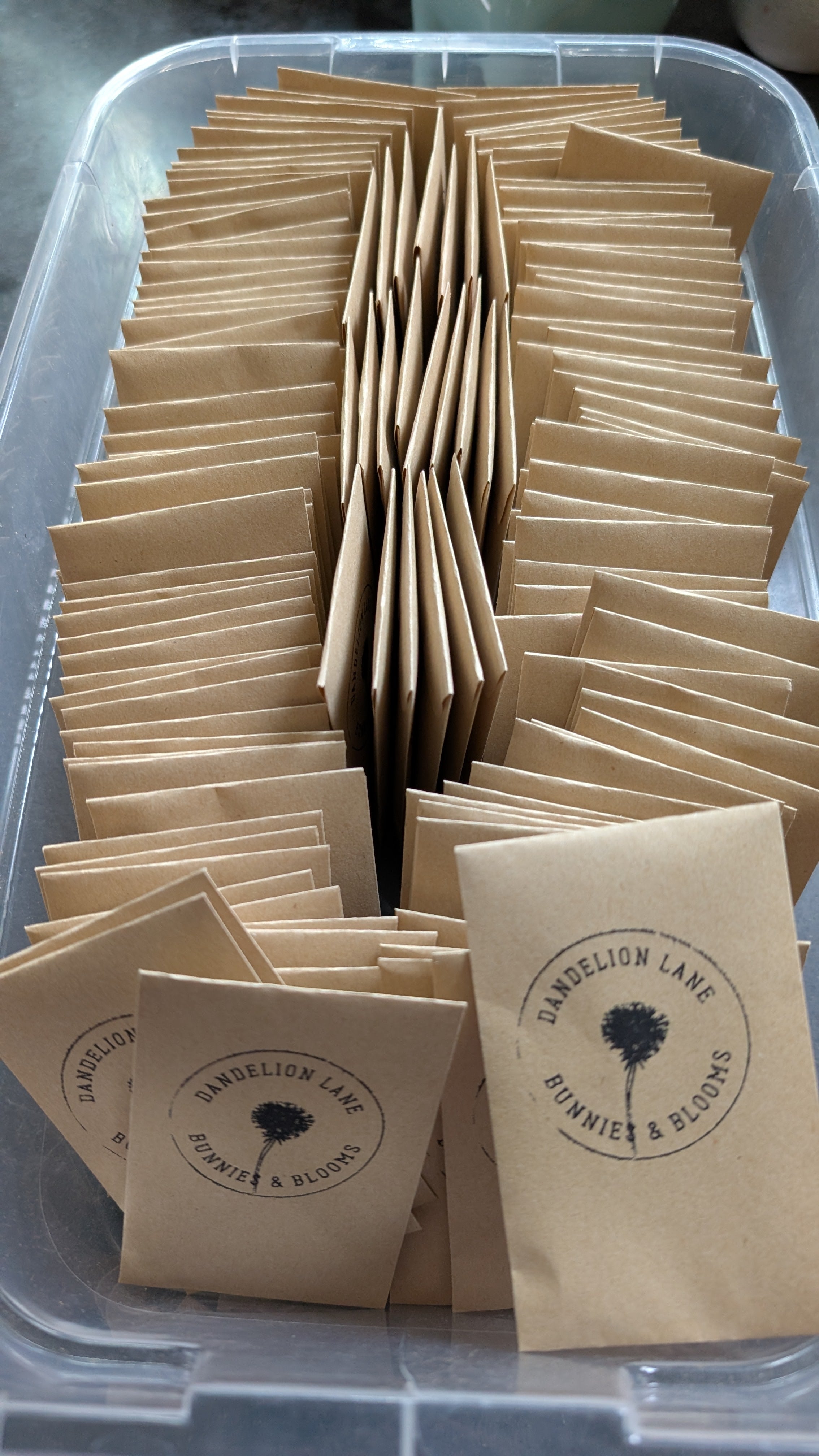 Clear container filled with brown paper bags with a visible brand logo.